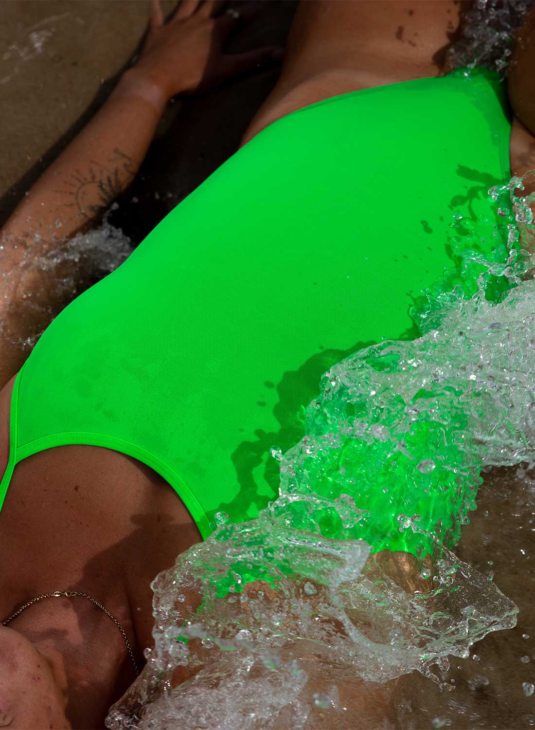 JAYD Swimwear, Zimmy one piece in the splice colour being splashed by water.