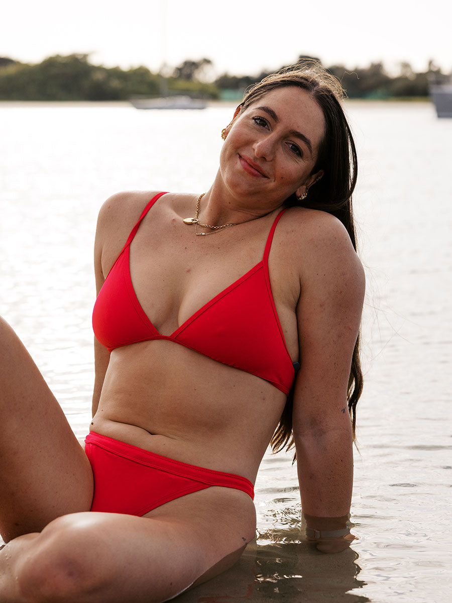 Athlete Jenaya wears the triangle tie-back top by JAYD Swimwear in the colour Ruby. This piece is built for both performance and leisure.