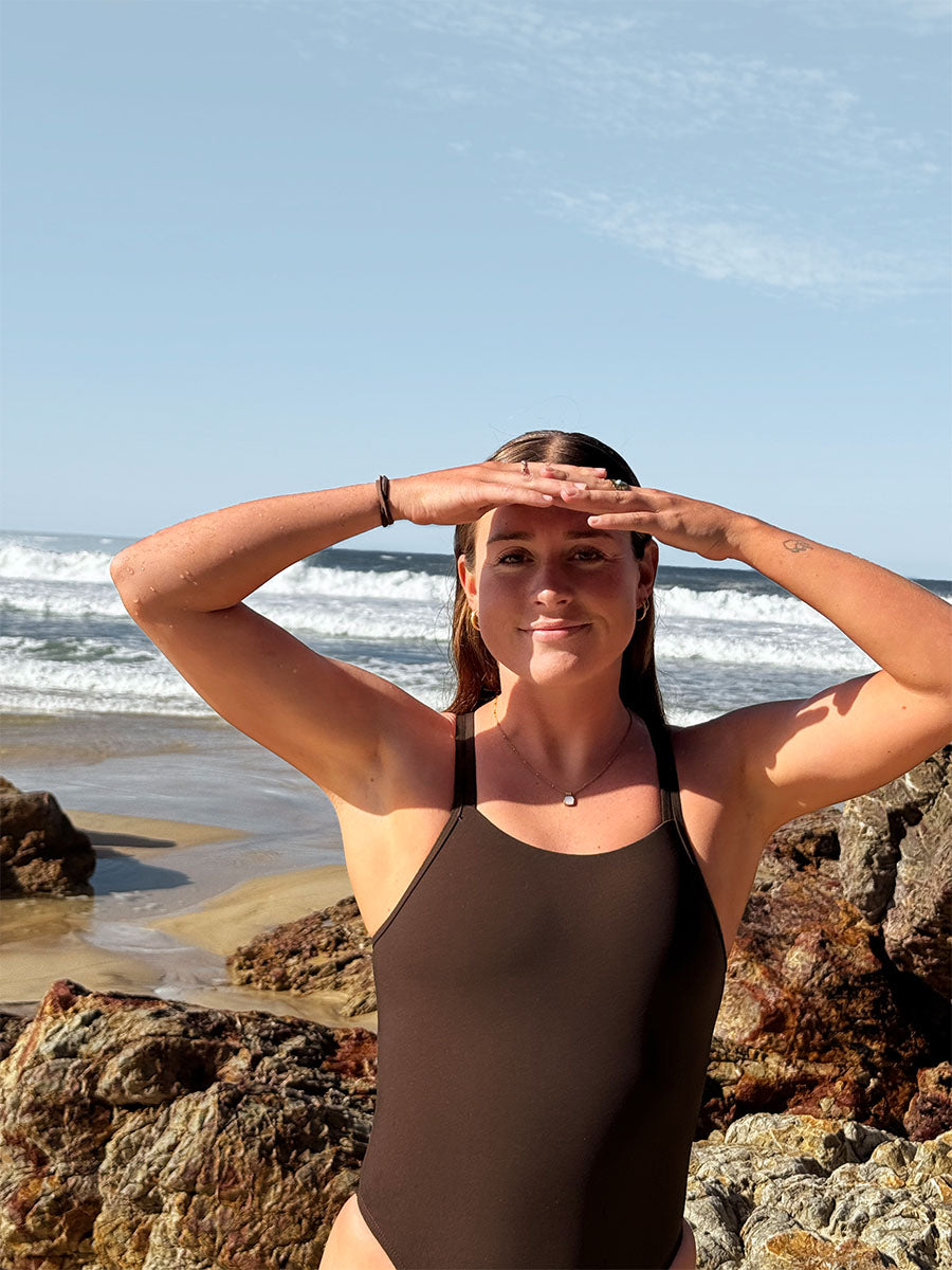 Triathlete Charlotte wears JAYD Swimwear's athletic, chlorine resistant one piece called Finley. This piece offers slim coverage and is built for performance. This double strapped fixed back is seen in the colour Cacao.