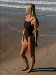 Keira wears the Albi one piece in Cacao, standing on the beach in Gold Coast Australia. One piece is chlorine resistant 