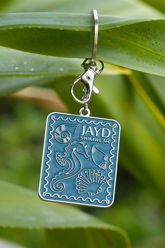 JAYD Swimwear shell stamp keyring, depicting a seahorse and various shells hanging on a branch.