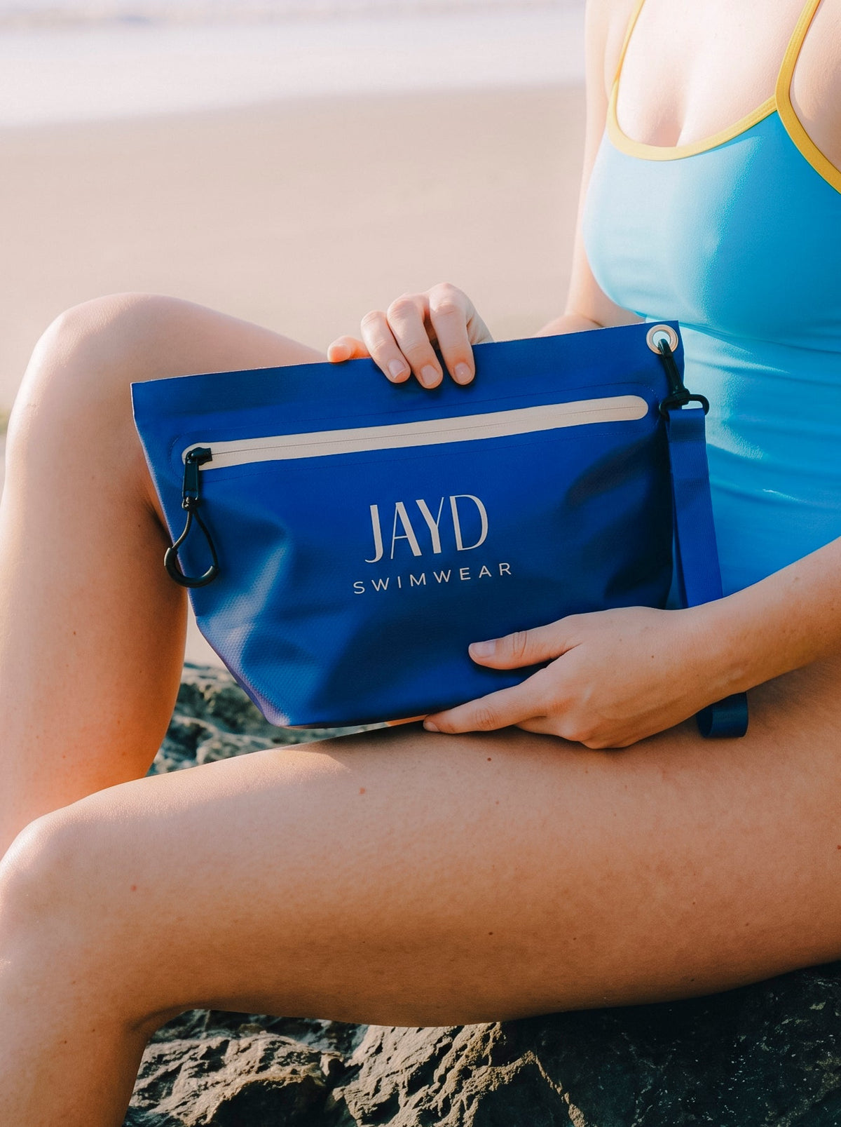 Model holding JAYD Swimwear blue dry bag